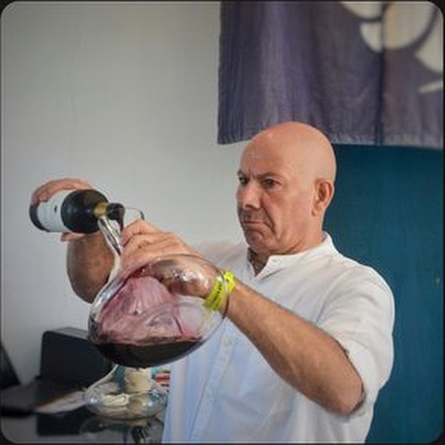 Daniel Reyes, Director, decanting a bottle of red wine